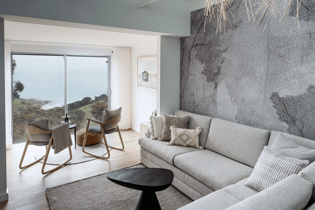 Elegant room at Sea Dragon Lodge on Kangaroo Island, featuring a cozy bed, warm natural decor, and large windows overlooking scenic views. This private retreat offers luxurious comfort with a coastal ambiance, perfect for relaxation after a day of exploring the island's natural beauty.
