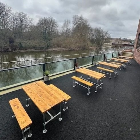 Outdoor bench seating by the River Aire