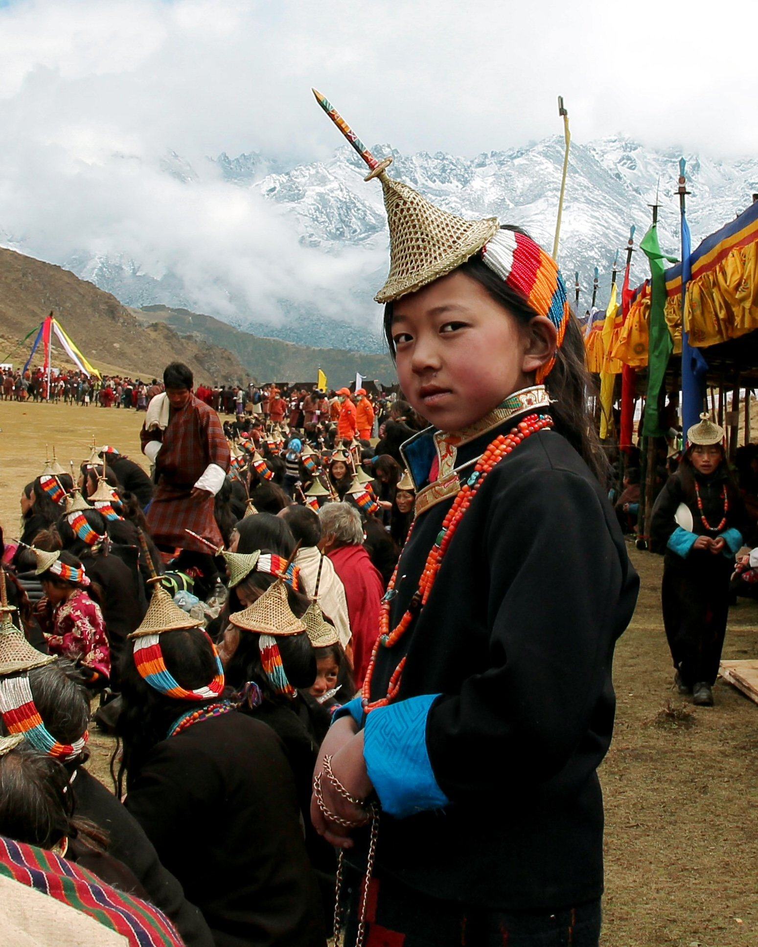 Young Layap girl in the traditional conical bamboo hat and black robe at the Royal Highland Festival, Laya, Bhutan
