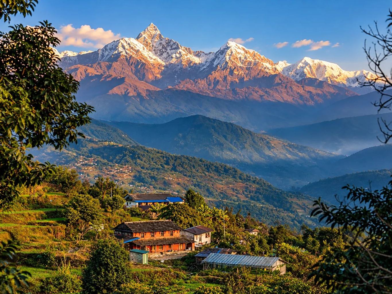 A hill village below Machhapuchhre and the Annapurna range in golden light, near Pokhara, Nepal