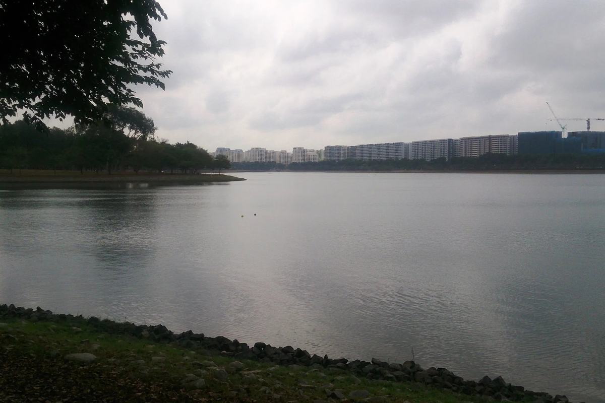 Bedok Reservoir under a grey sky, with flats along the far shore, Singapore