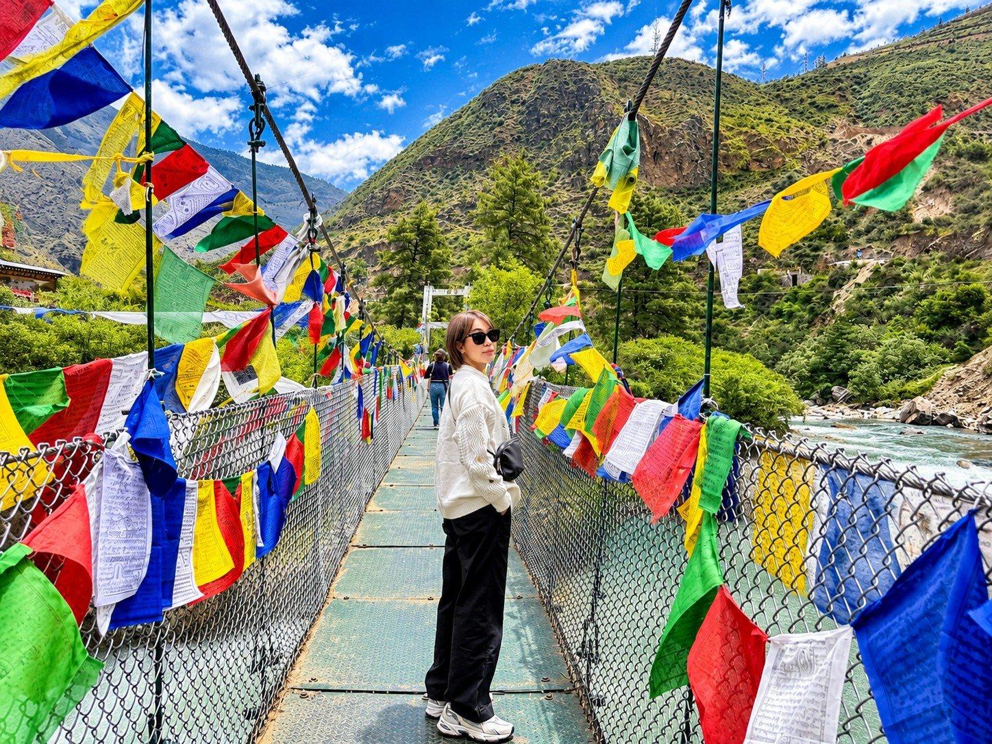 Prayer flags on a suspension bridge over the river