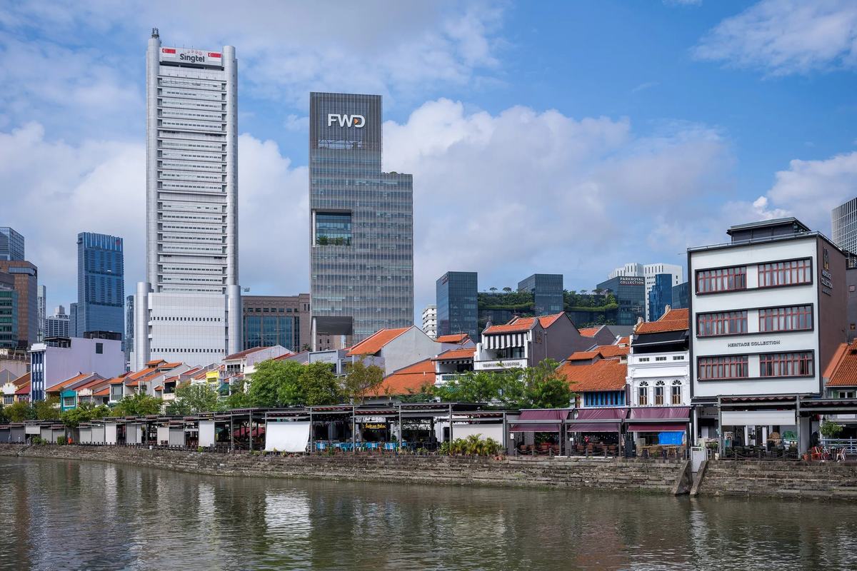 Boat Quay's shophouses along the Singapore River, with the CBD towers behind
