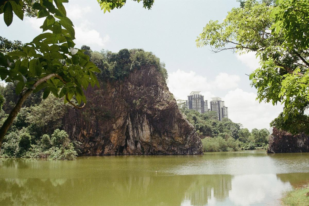 The flooded quarry at Bukit Batok framed by trees, with tower blocks beyond, Singapore