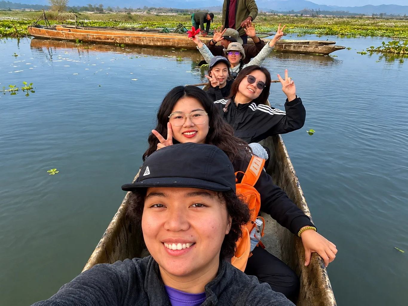 Travellers taking a selfie in a dugout canoe on the river at Chitwan, Nepal