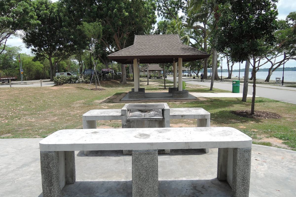 A pavilion and barbecue tables under shade trees at Changi Beach Park, Singapore