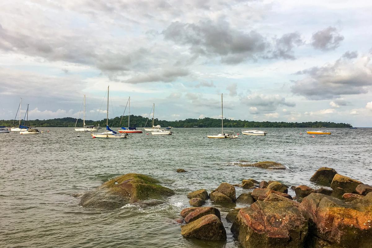 Yachts moored off the rocky shore of Changi Beach Park, Singapore