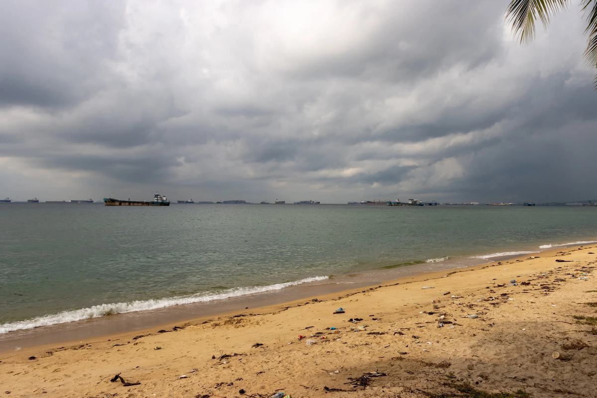 Storm clouds over the sand and sea at East Coast Park, Singapore