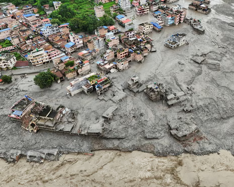 Flood-damaged buildings along the river corridor, August 2026.