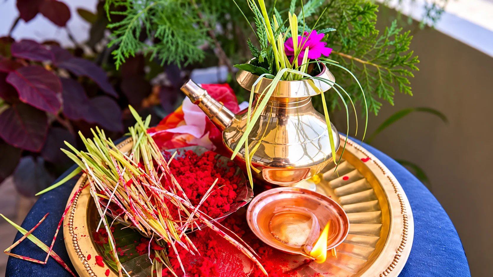 A brass puja tray with a kalash, jamara shoots, red vermilion and an oil lamp for Dashain worship, Nepal
