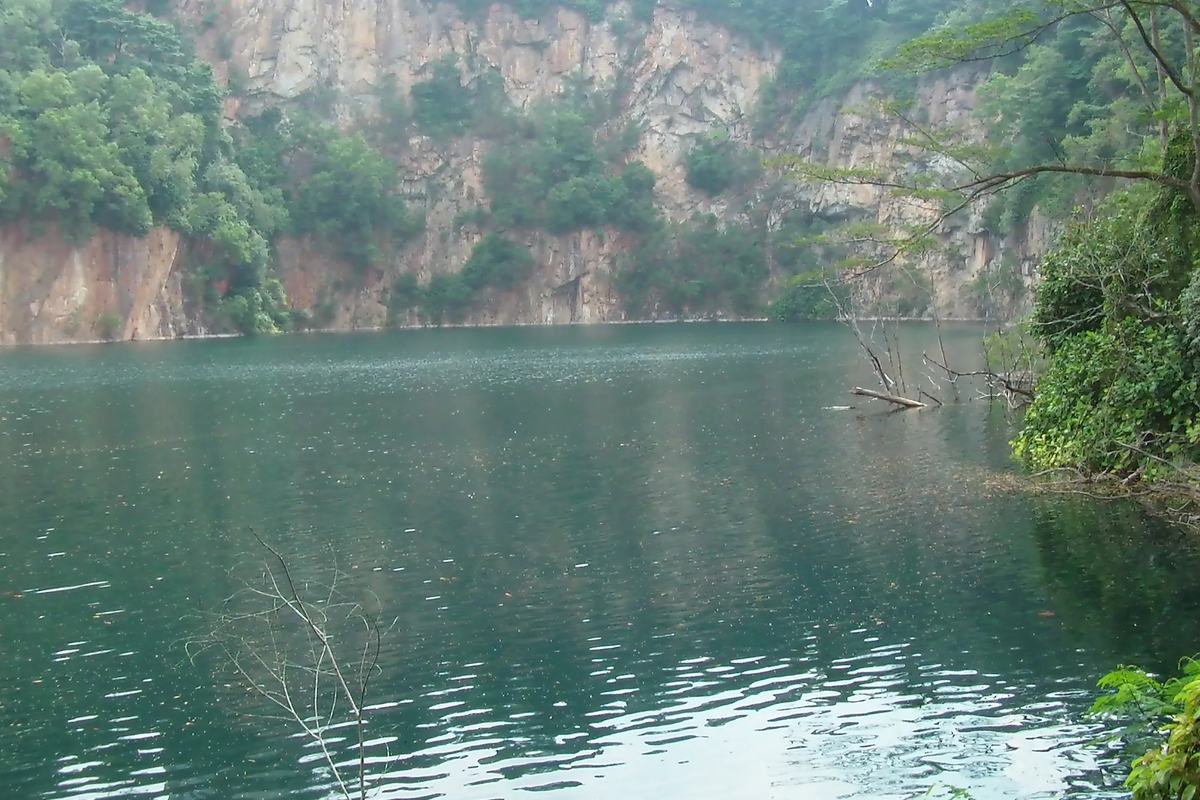The green lake of Hindhede Quarry beneath its rock face, Singapore