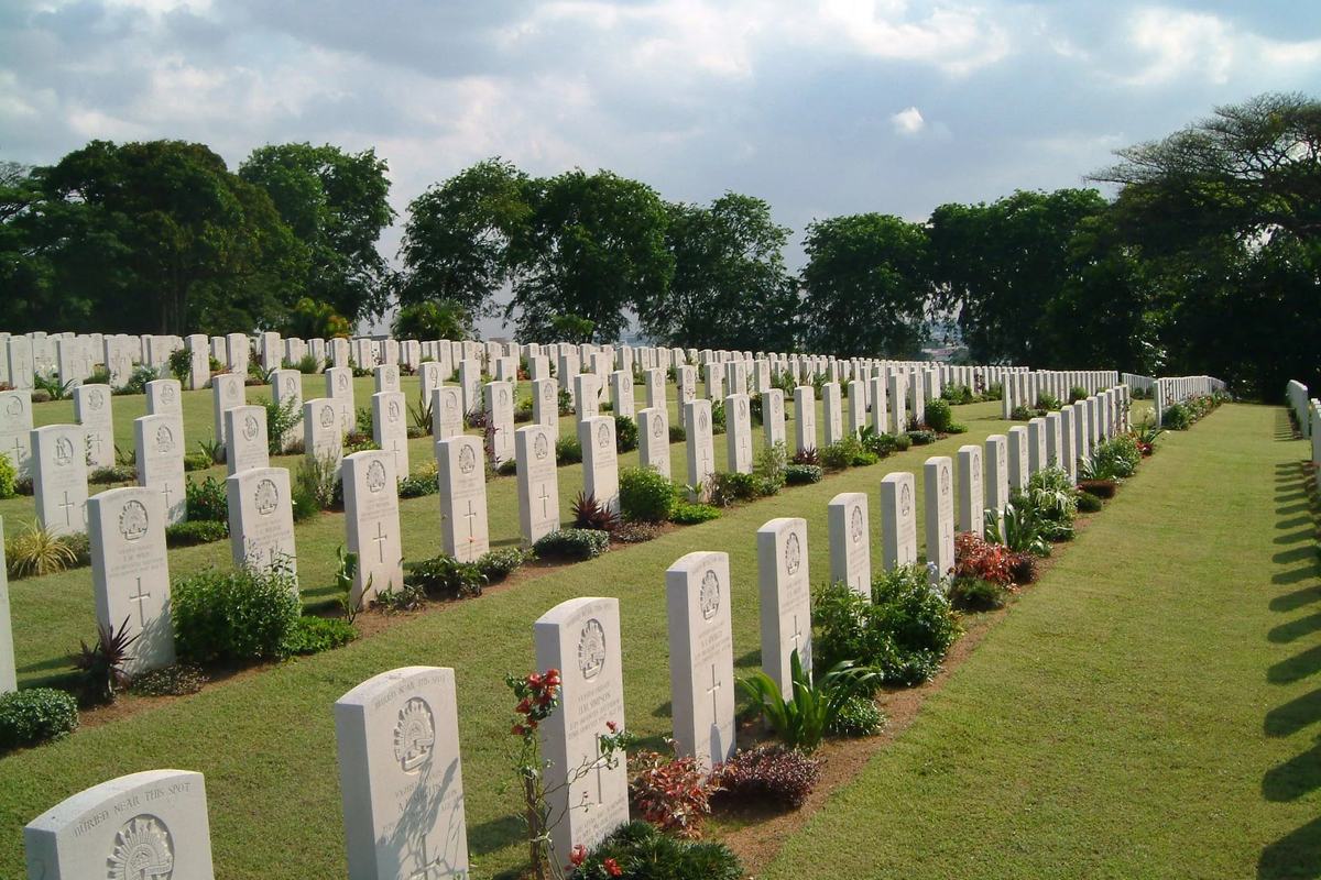White headstones and flowers in rows at Kranji War Cemetery, Singapore