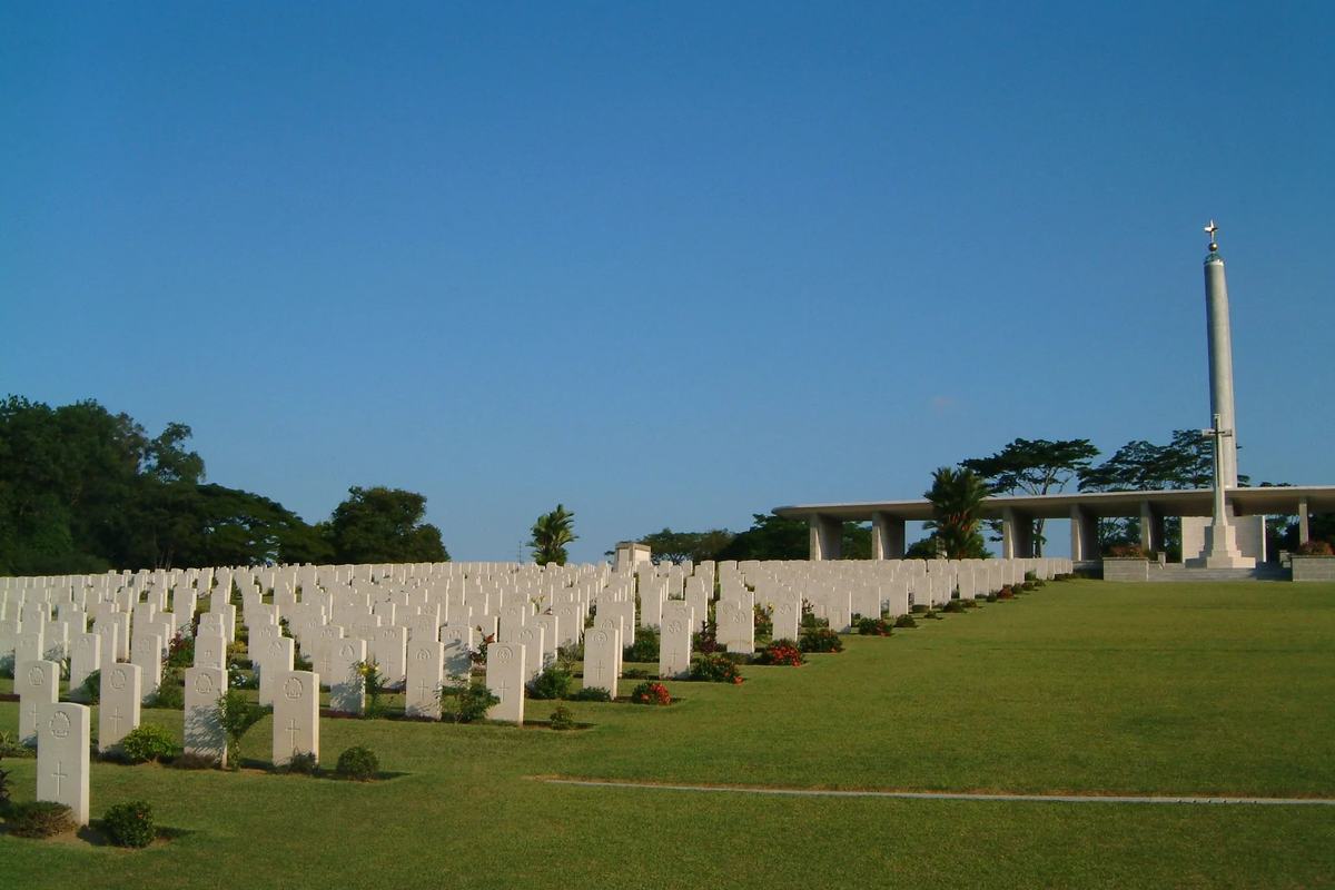 Rows of headstones and the memorial column at Kranji War Cemetery, Singapore