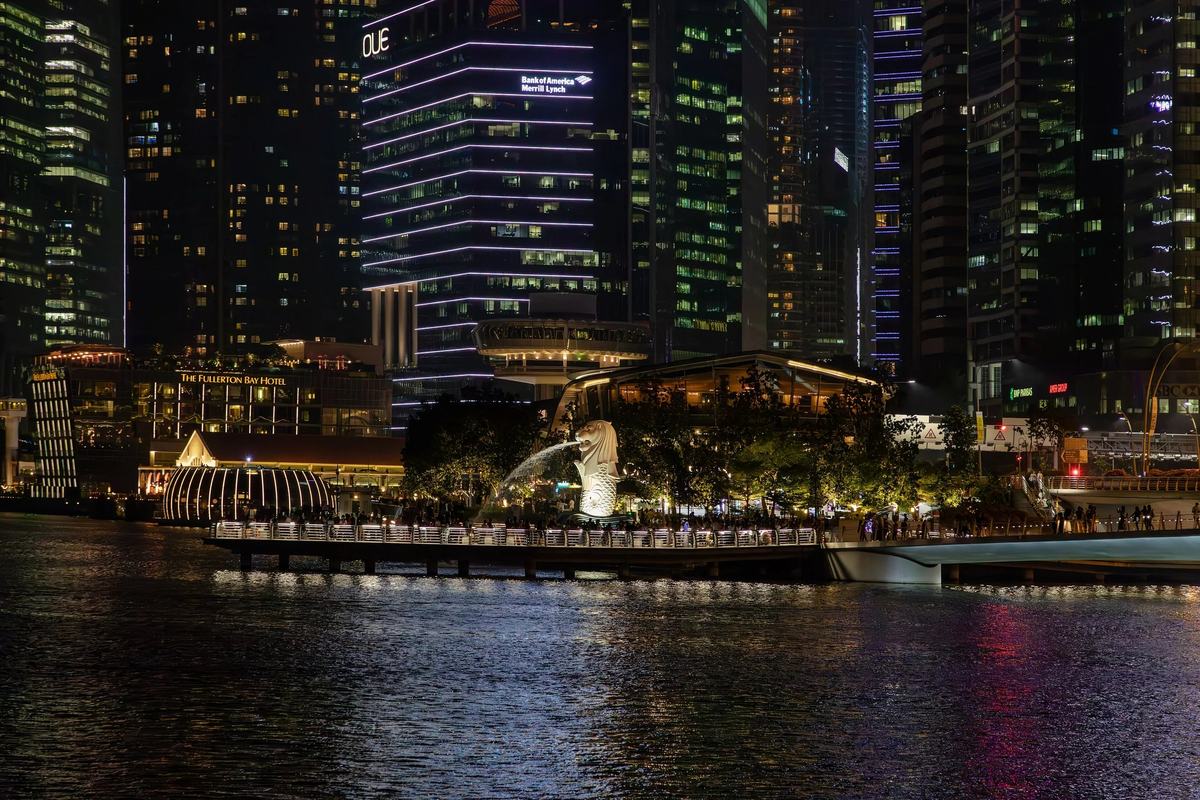 The Merlion and the waterfront below the lit CBD towers at night, Singapore