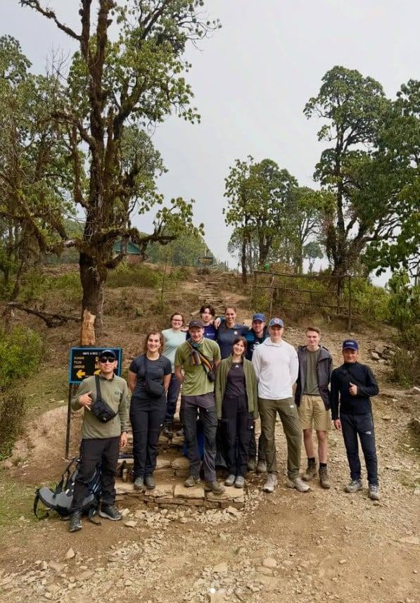 Mingmar Sherpa, Tour Leader, with an HSJ trekking group at a trail junction in Nepal
