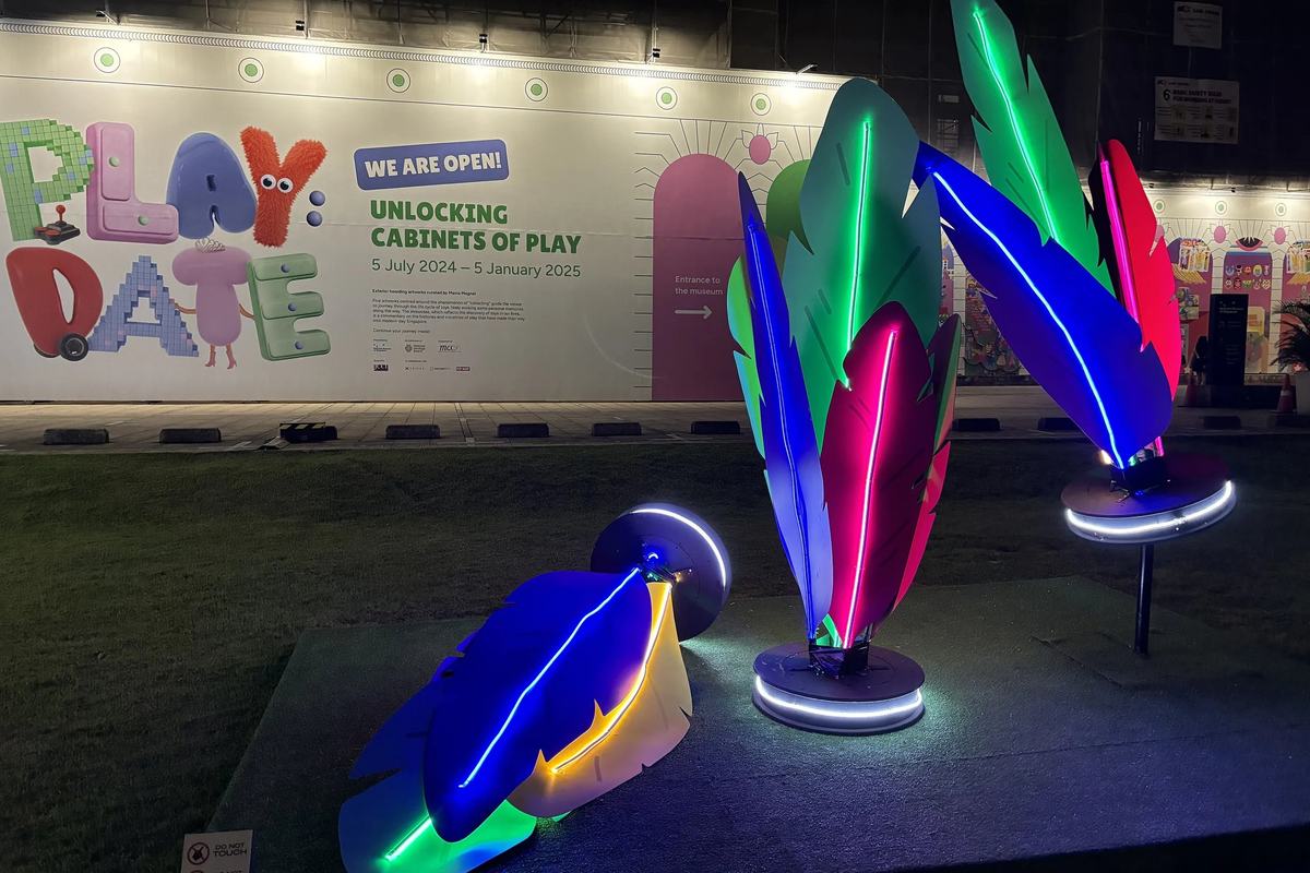Neon feather sculptures on the lawn of the National Museum at night, Singapore