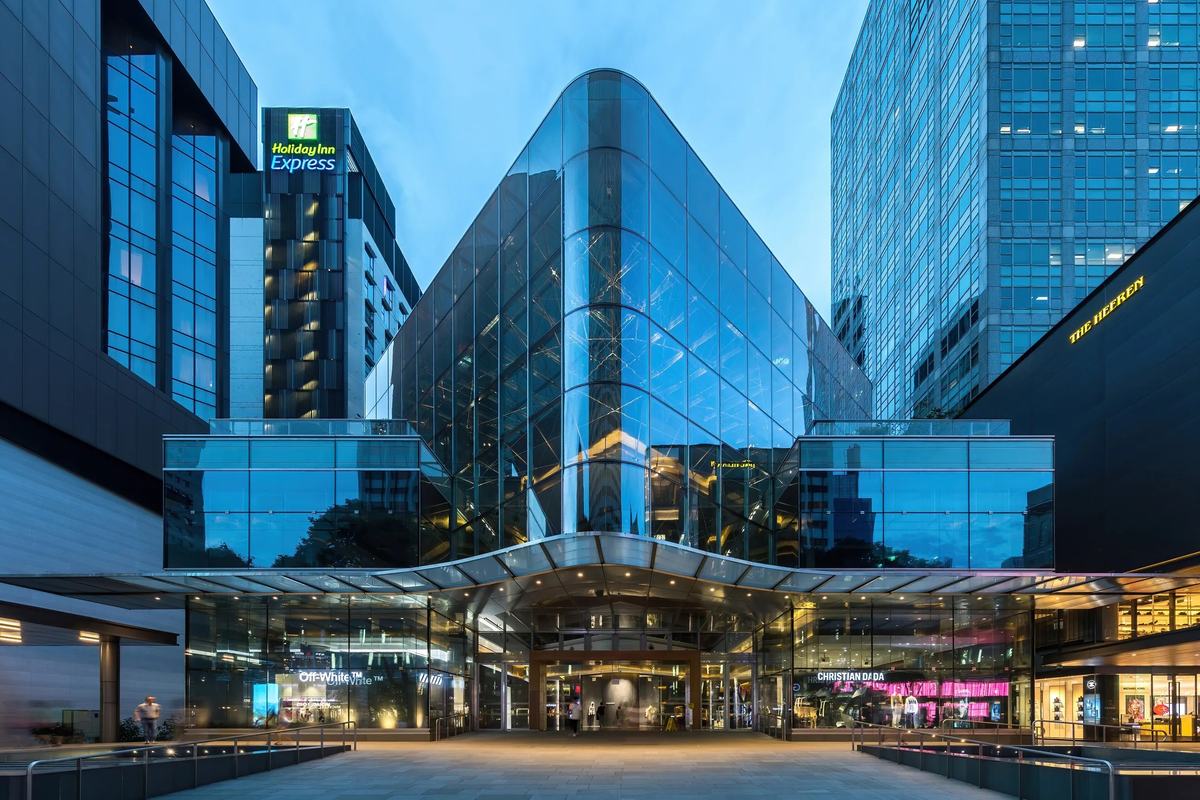 A glass-fronted shopping centre on Orchard Road at dusk, Singapore