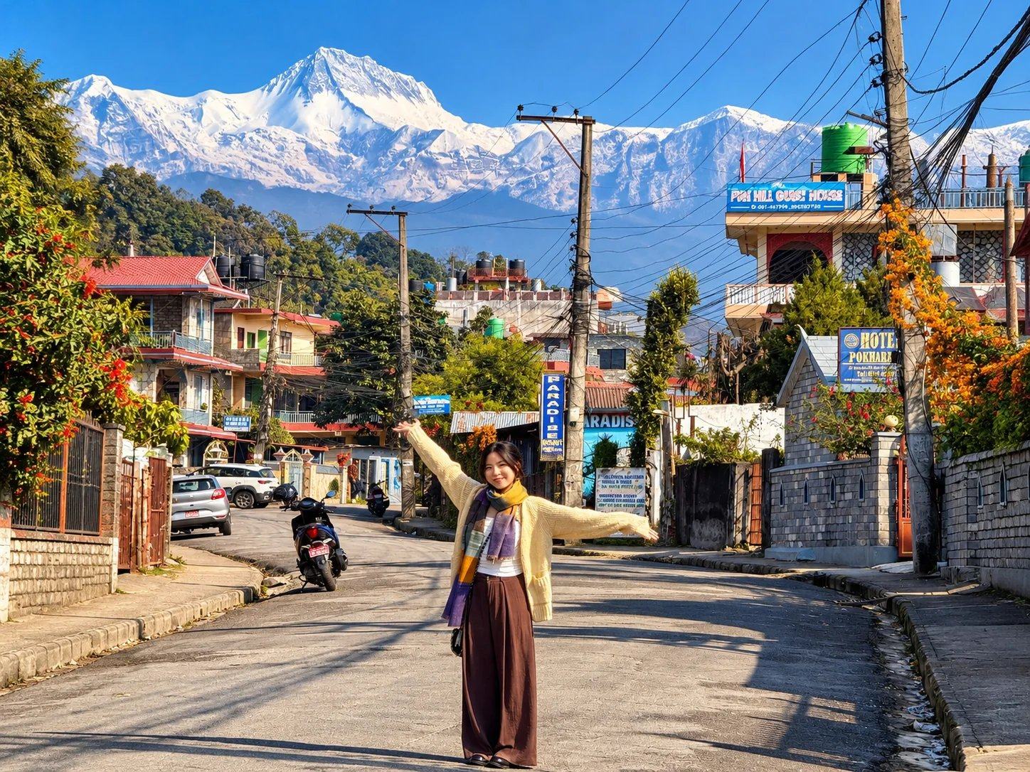A traveller on a street in Pokhara with the snowy Annapurna range behind, Nepal