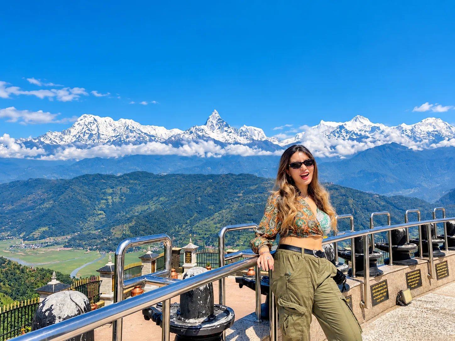 A traveller at a hilltop viewpoint above Pokhara with Machhapuchhre and the Annapurna range behind, Nepal