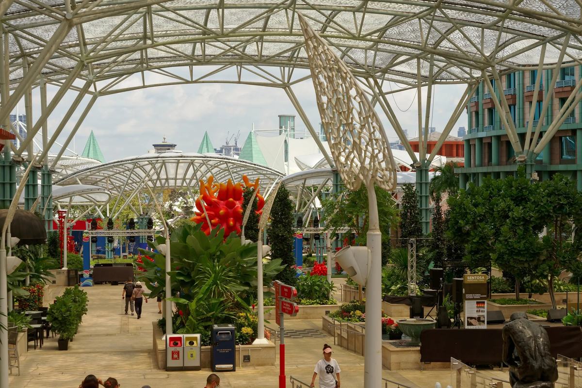 Visitors walking under the glass canopy at Resorts World Sentosa, Singapore