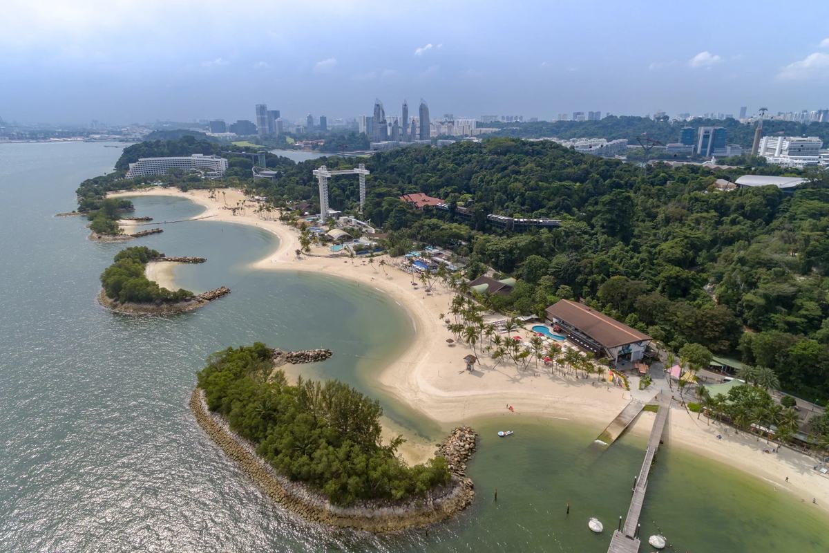 Siloso Beach's curving sand and islets on Sentosa from above, Singapore