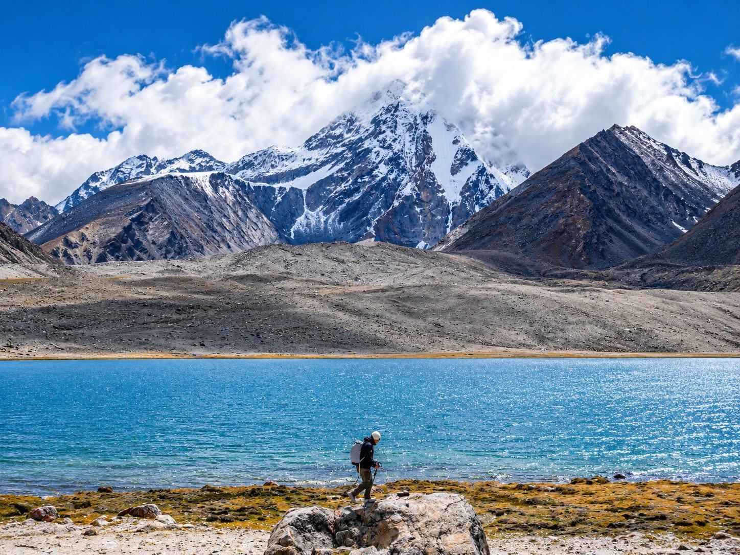 A turquoise lake below the snow peaks