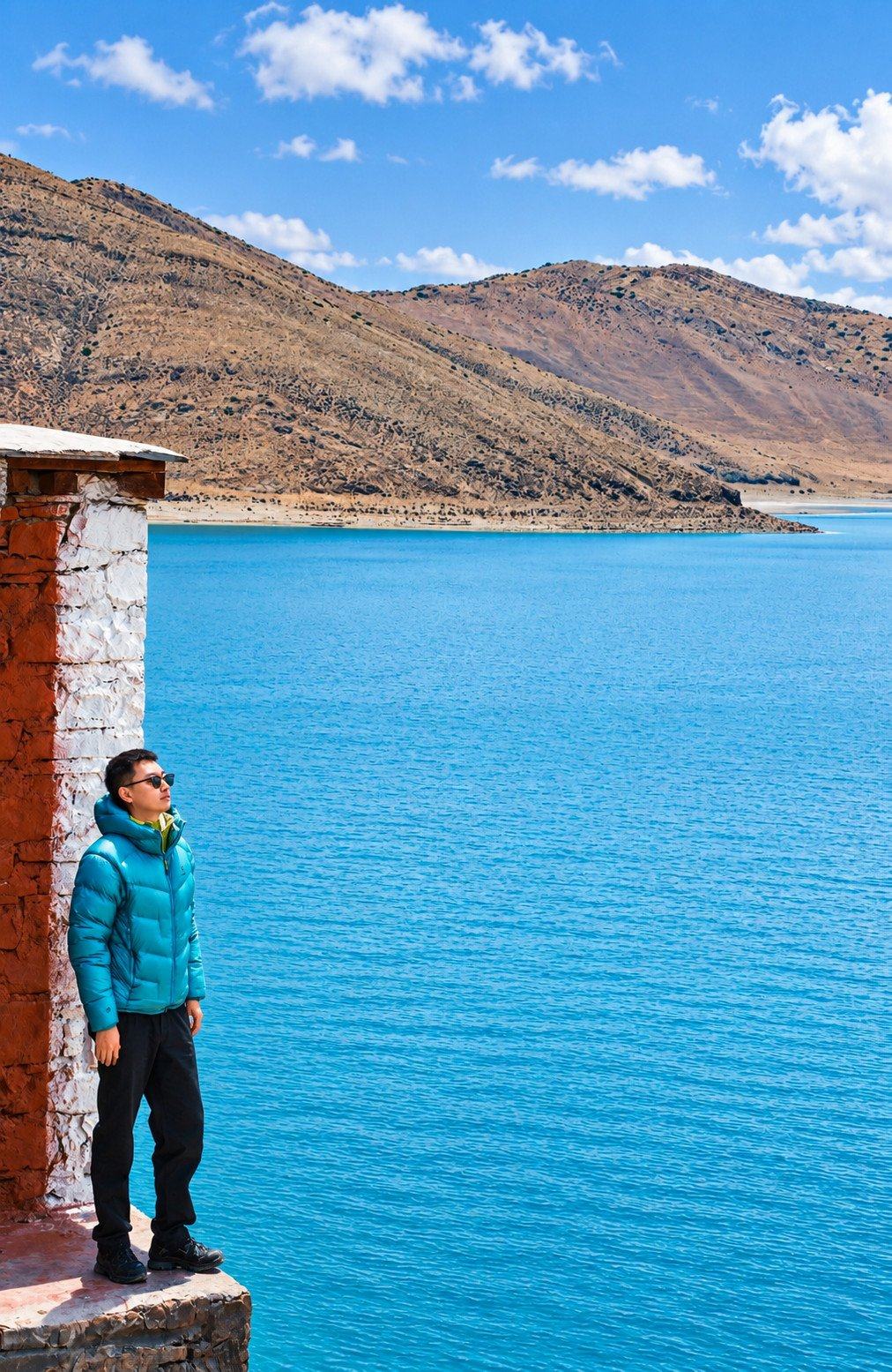 A turquoise lake below brown hills, Tibet