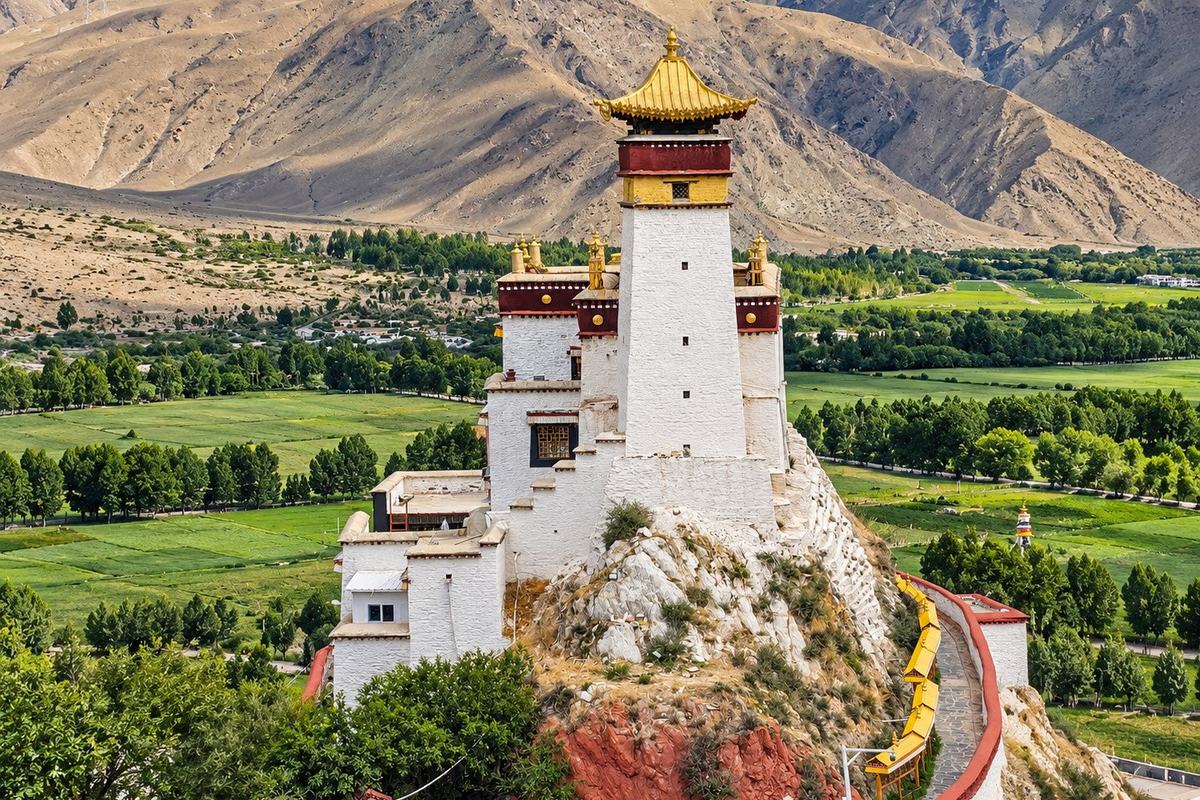 Yumbulagang, the old palace tower on its rocky ridge above the green Yarlung valley, Tibet
