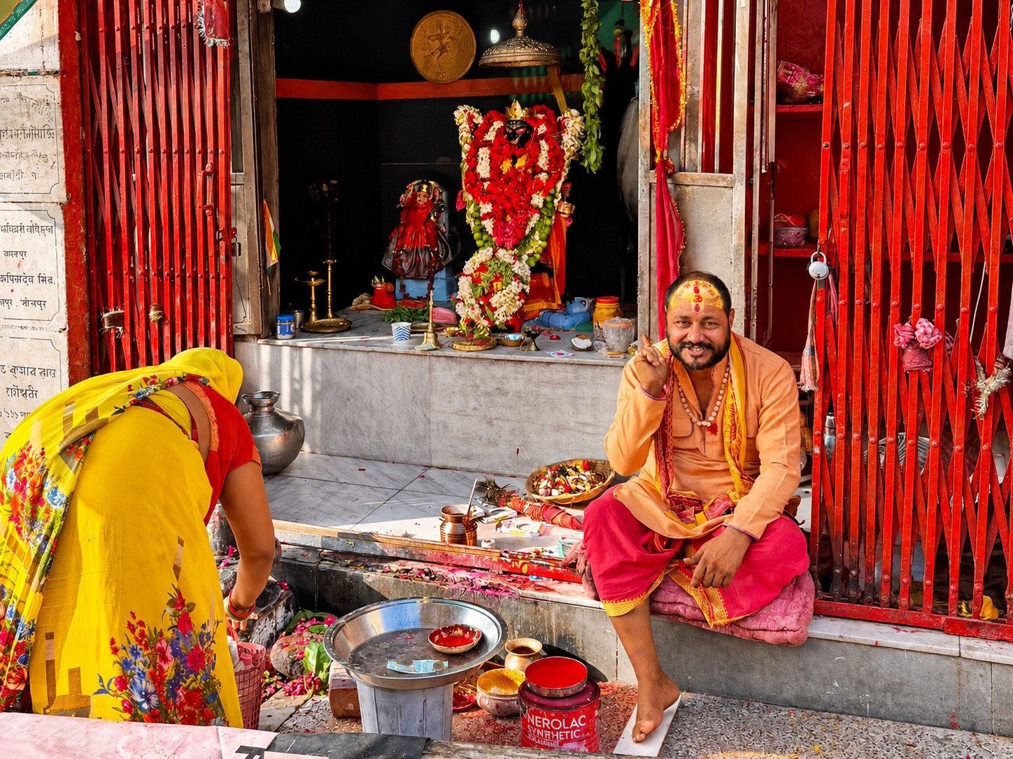 A priest and offerings at a street shrine