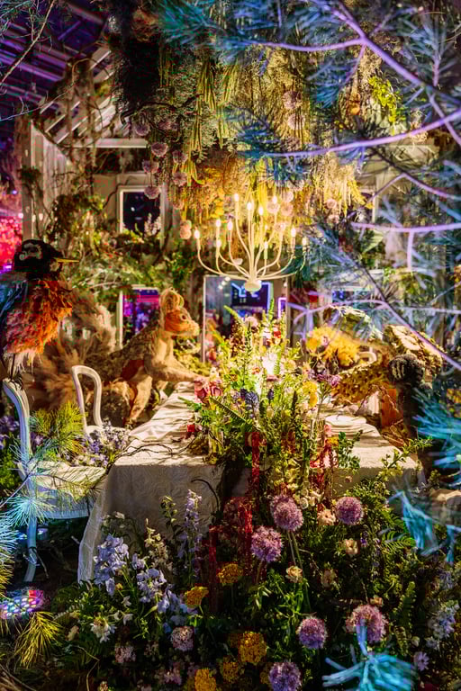Elaborate floral installation with chandelier and whimsical table setting at Philadelphia Flower Show