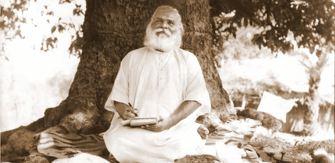 Anant Shri Sadguru Sadafal Deo Ji Maharaj seated under a large tree, with His Holy Scripture the Swarved.