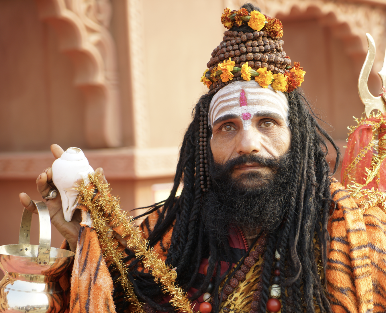 A Nāga Sadhu at the Kumbh Mela, dressed in orange garb.