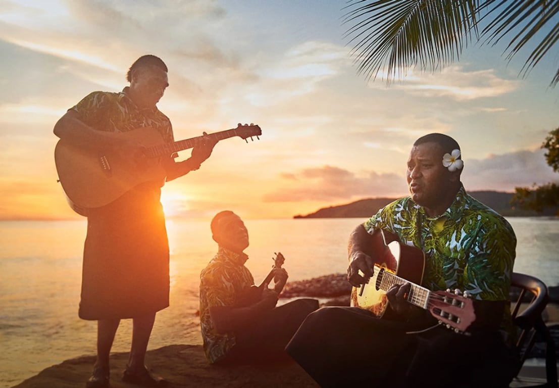 3 fijjian men playing melodies as the sunsets