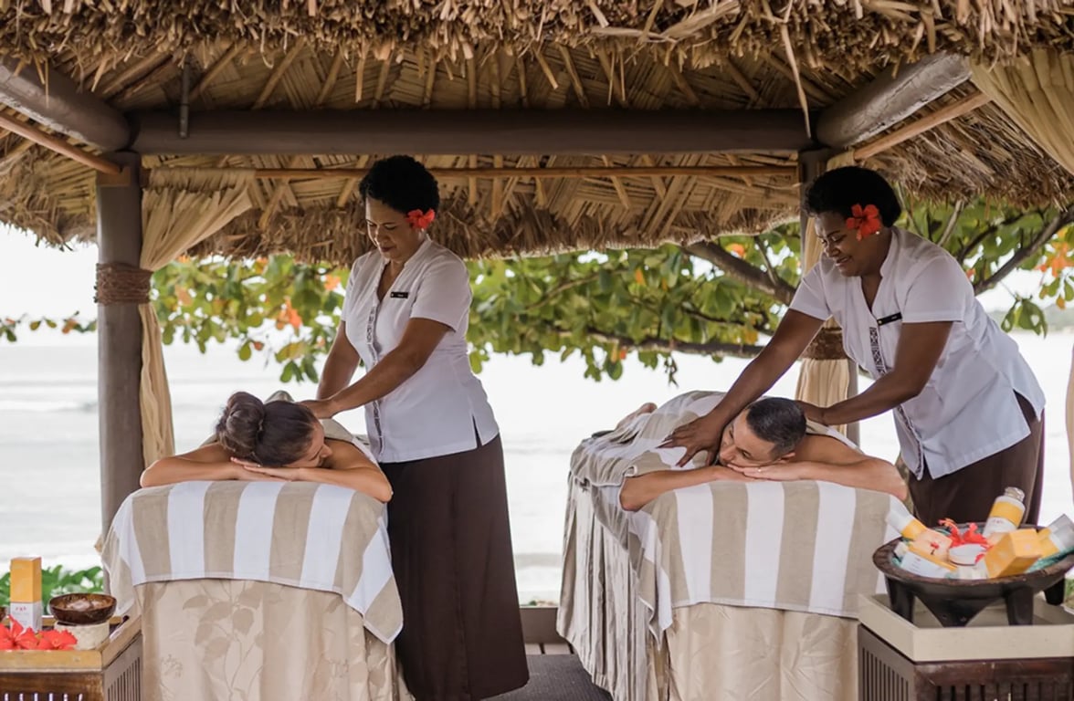 people enjoying a fijian massage on the beach