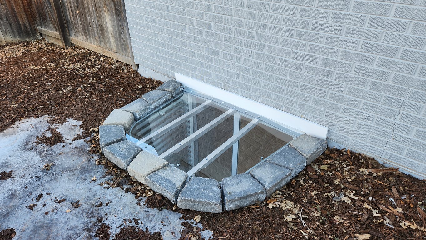 Clear custom polycarbonate window well cover installed in Aurora Colorado by USA Window Well Covers