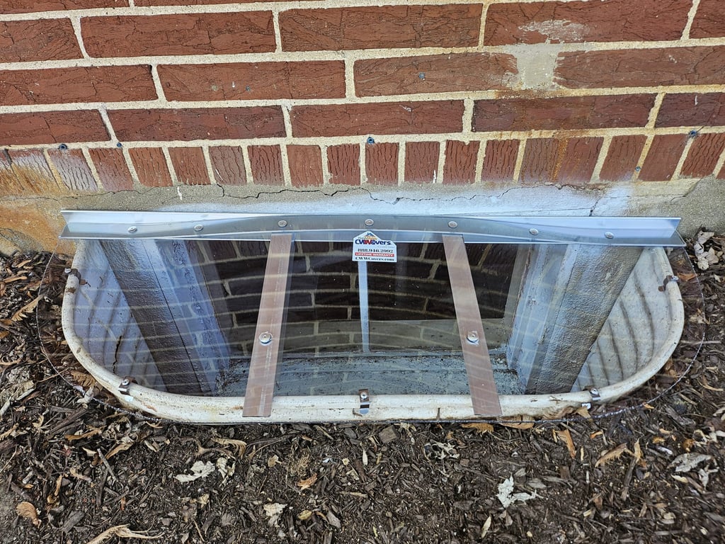Custom made clear polycarbonate window well cover with clips installed near Chesterton Indiana