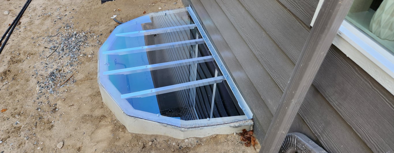 Clear polycarbonate window well cover installed on a concrete window well 75x45 in Golden Colorado