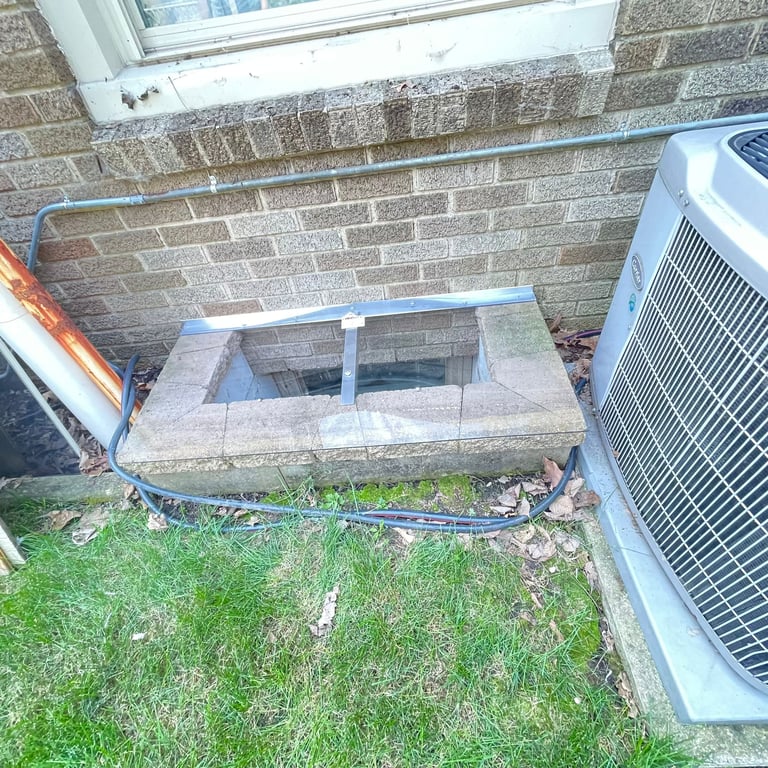 Small clear polycarbonate window well cover with clips installed on a concrete block window well in Chicago Illinois