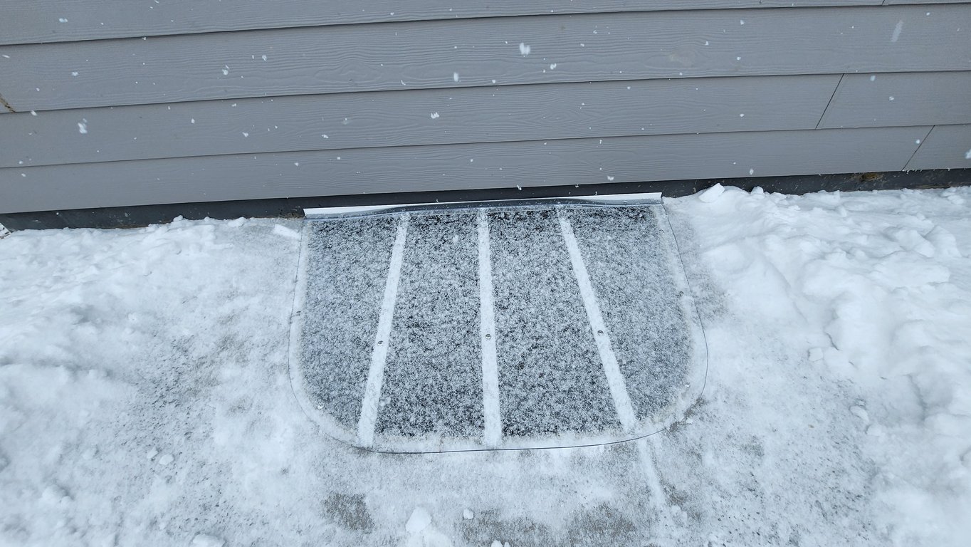 Window well cover full of snow installed in Westmont Illinois for winter protection