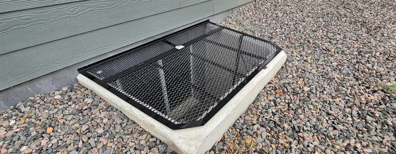Custom powder-coated metal grate window well cover installed on a concrete well in Rolling Meadows Illinois