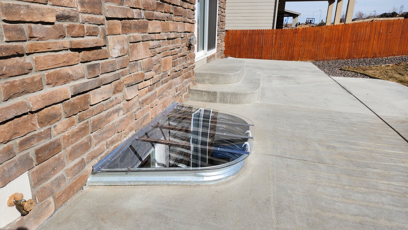 Heavy-duty UV-protected GE Lexan window well cover supporting up to 800 lbs installed in Elgin Illinois