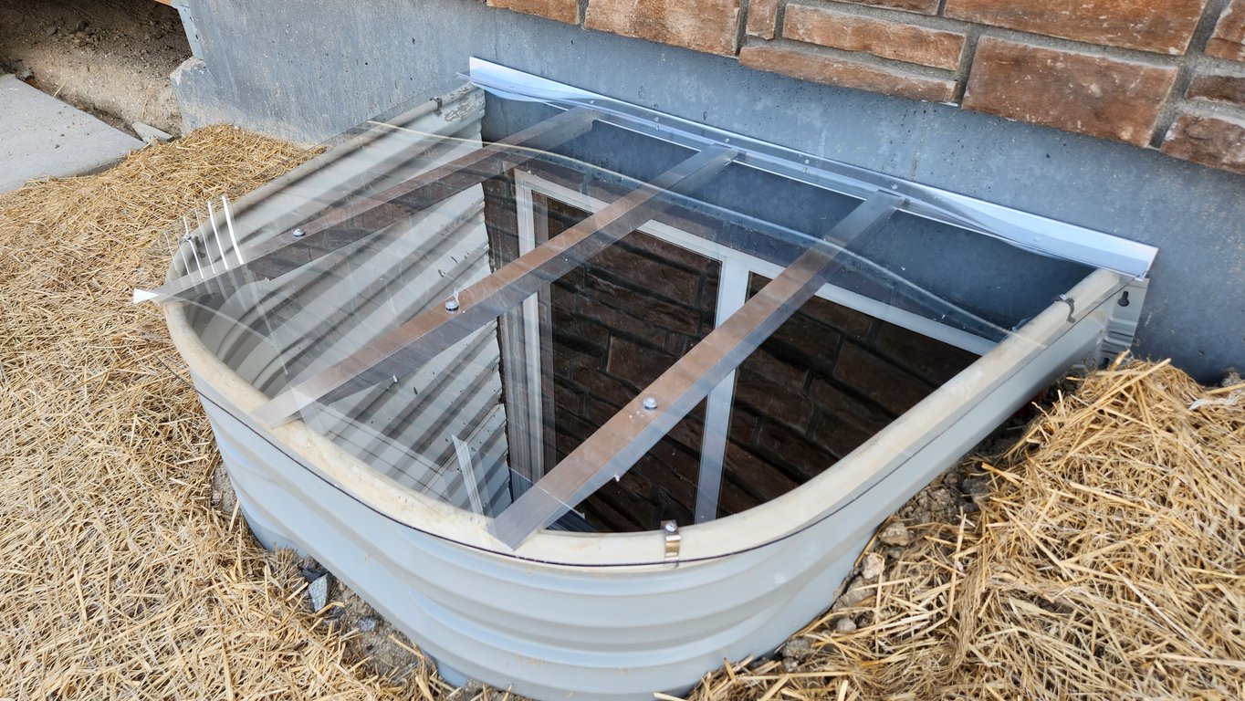Sloped clear polycarbonate window well cover custom made onsite for perfect fit in Broomfield Colorado
