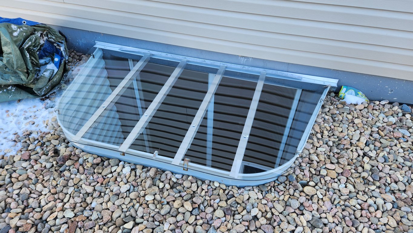 Transparent polycarbonate window well cover designed to protect and brighten basement spaces in Lake Barrington Illinois