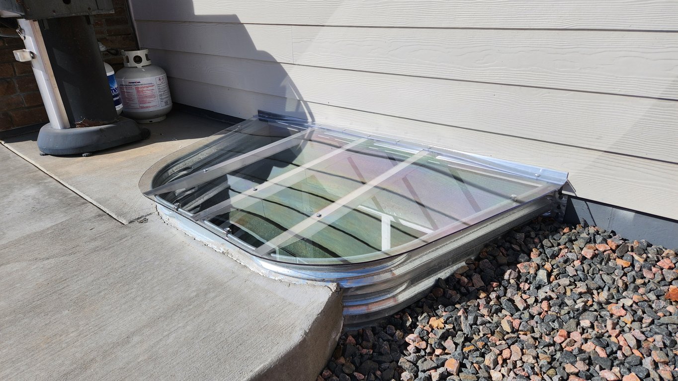 Custom clear window well cover with secure mounting system for safety and strength installed in Lake Barrington Illinois