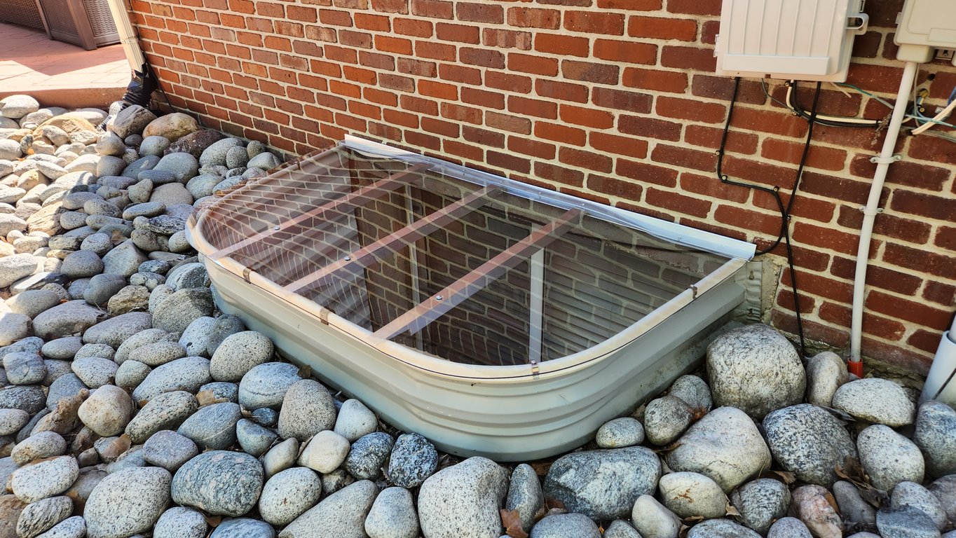 Clear polycarbonate basement window well cover installed on site in Bolingbrook Illinois for an exact fit