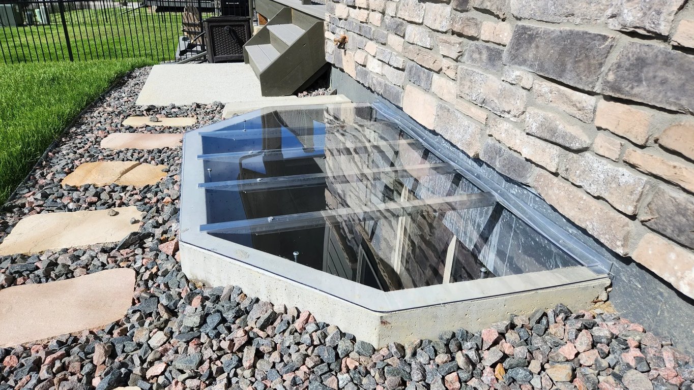 Sloped polycarbonate window well cover with locks installed in Woodland Park Colorado