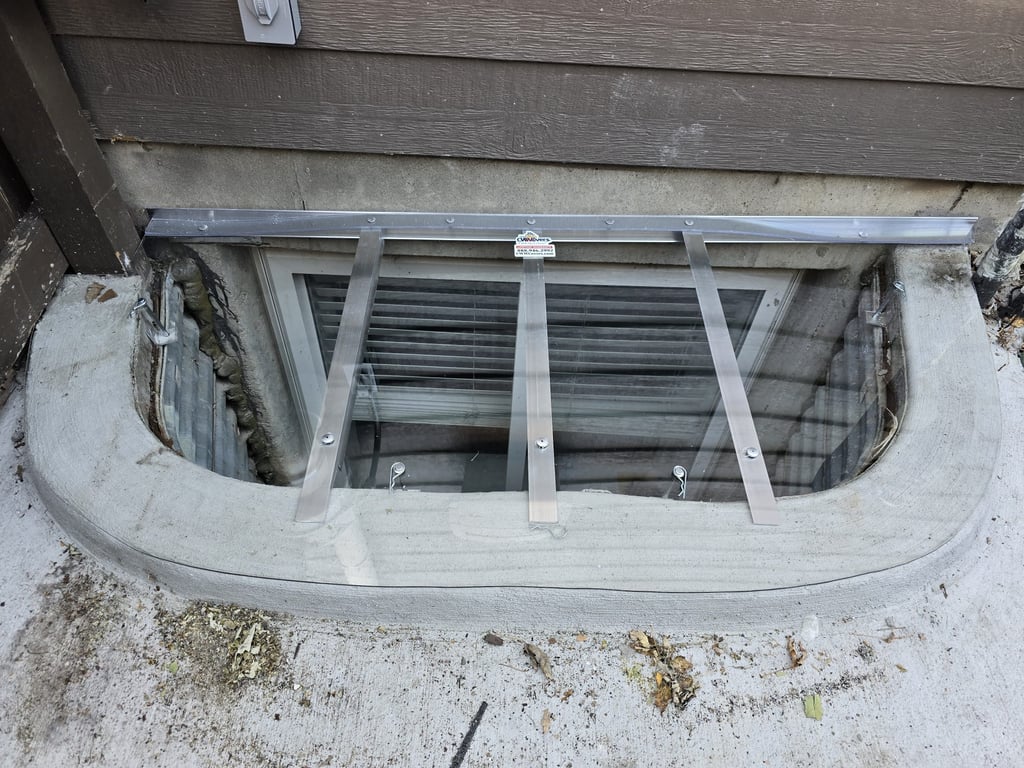 Clear polycarbonate window well cover installed on a patio area with locks in Lone Tree Colorado