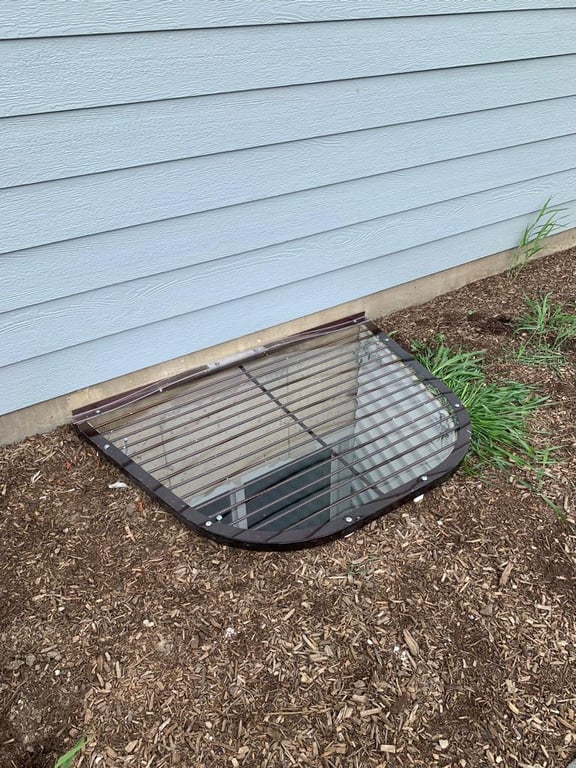 57x38 polycarbonate overlay window well cover with locks installed on metal grate in Colorado Springs Colorado