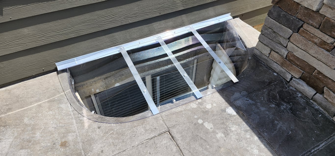 Clear polycarbonate window well cover allowing natural light while keeping debris and water out in Elgin Illinois