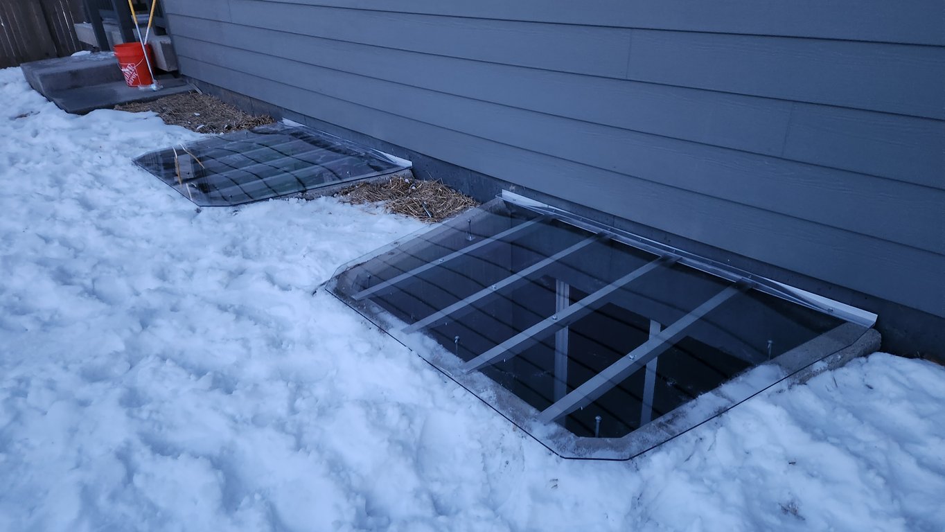 Two custom window well covers with locks installed in Lombard Illinois with snow around the window wells